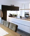 Cucina moderna con tavolo da pranzo e lampade a sospensione, presentata da Nolte Kitchen.
