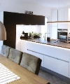 Cucina moderna con tavolo da pranzo e lampade a sospensione, presentata da Nolte Kitchen.