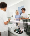 Un couple plie des serviettes dans une salle de bain moderne, miroir en arrière-plan, Nolte SPA.