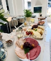 Une table de petit-déjeuner bien garnie dans une cuisine moderne avec charcuterie et fromage, conçue par Nolte Kitchen.