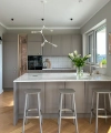 Modern kitchen with gray cabinets, island, and floral decor. Nolte Kitchen.