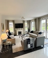 Un salon avec canapés et fauteuils, décoré de coussins et couvertures. Nolte Living.