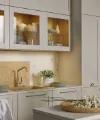 Une cuisine élégante avec vitrines en verre et accents de marbre. Nolte Küchen.