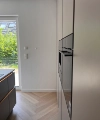Cuisine moderne avec électroménagers intégrés et parquet clair, design Nolte Kitchen.