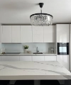 Cuisine moderne avec intérieur blanc et lustre, conçue par Nolte Kitchen.