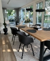 Modern dining area with wooden table, black chairs, large windows, styled by Nolte Living.