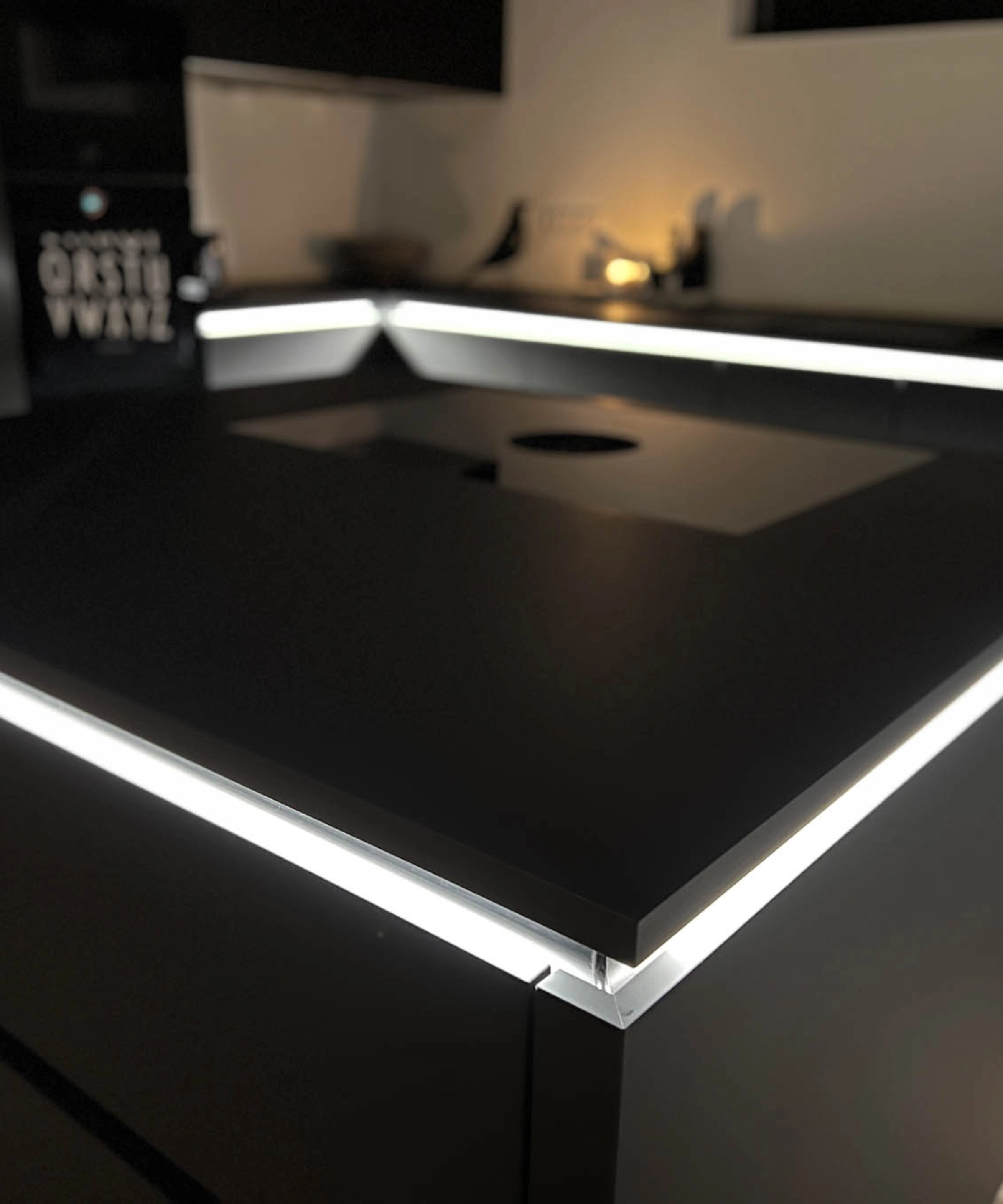 Cucina moderna nera con isola illuminata, progettata da Nolte Kitchen.