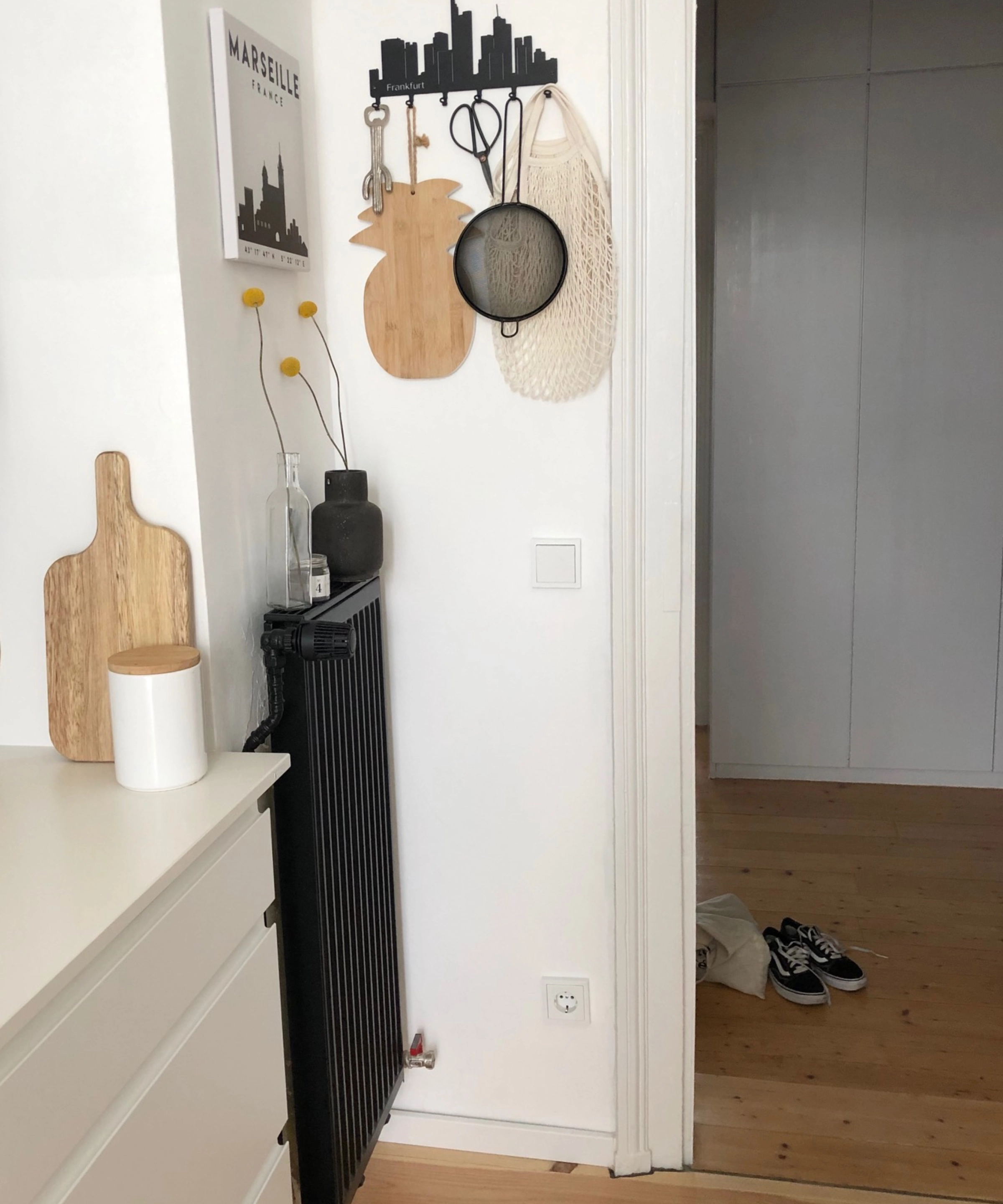 Un couloir avec un sol en bois et des objets muraux décoratifs, présenté par Nolte Kitchen.