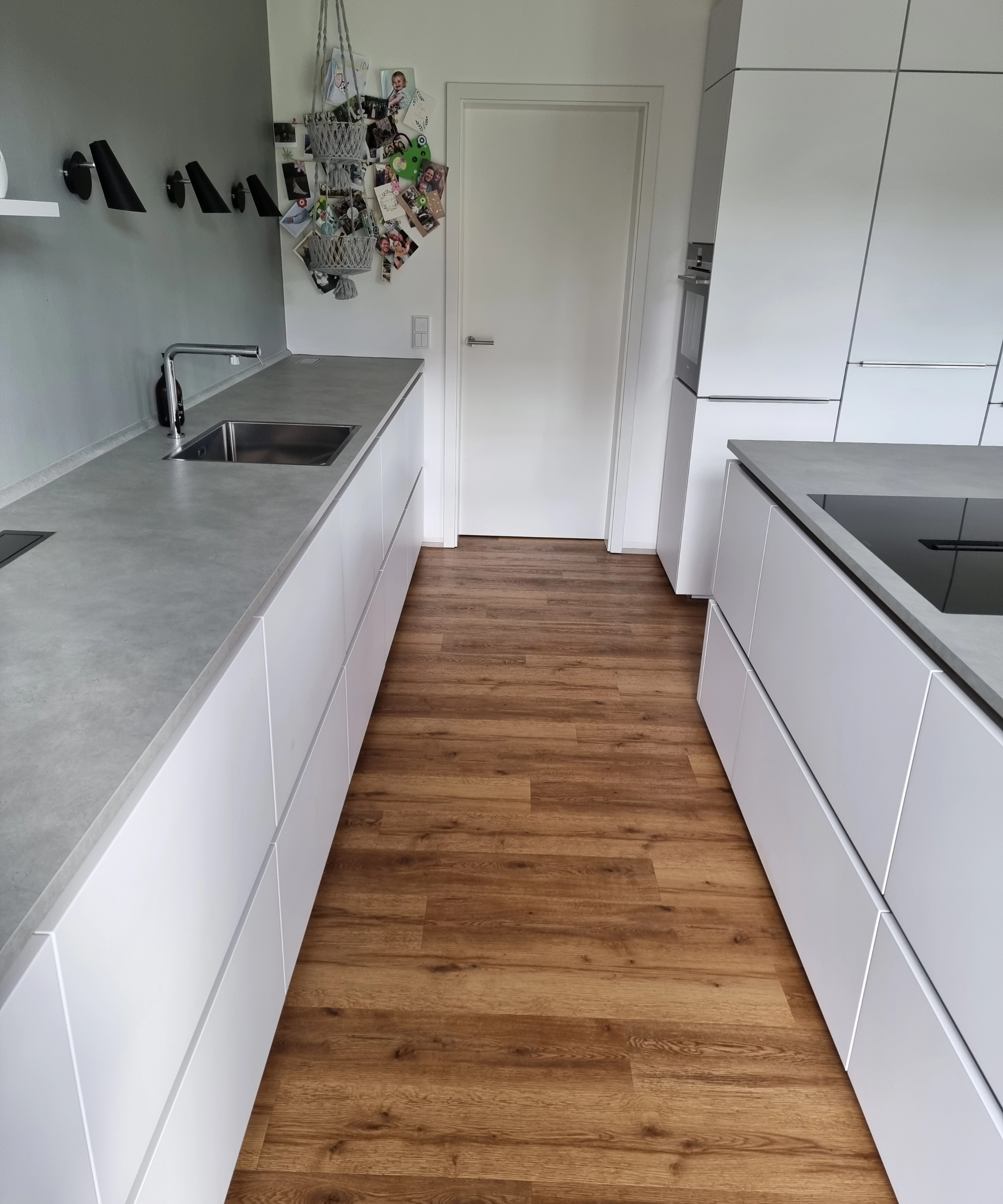 Een moderne keuken met witte kasten en houten vloer, Nolte Kitchen.