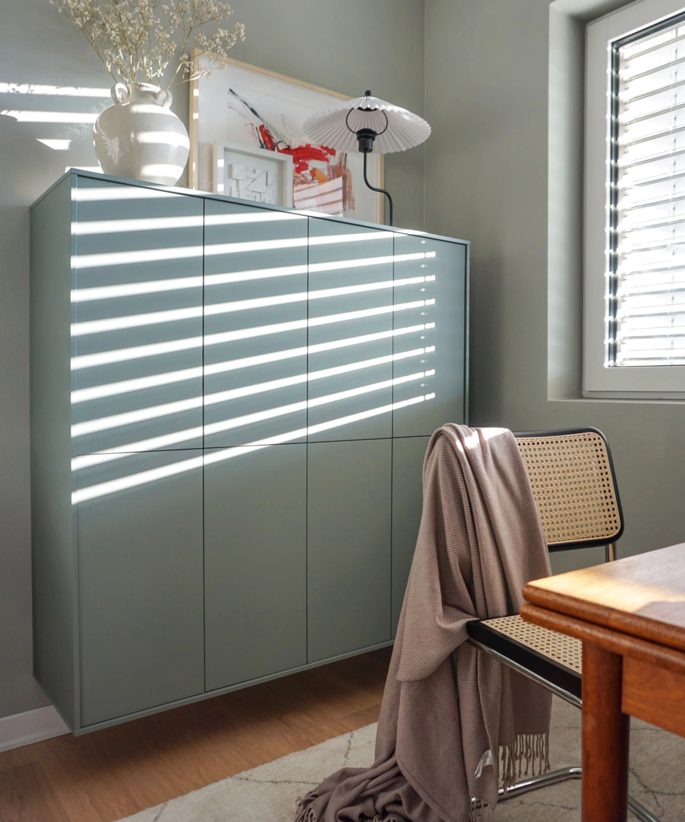 Un salon élégant avec armoire et chaise modernes, assortis à Nolte Living.