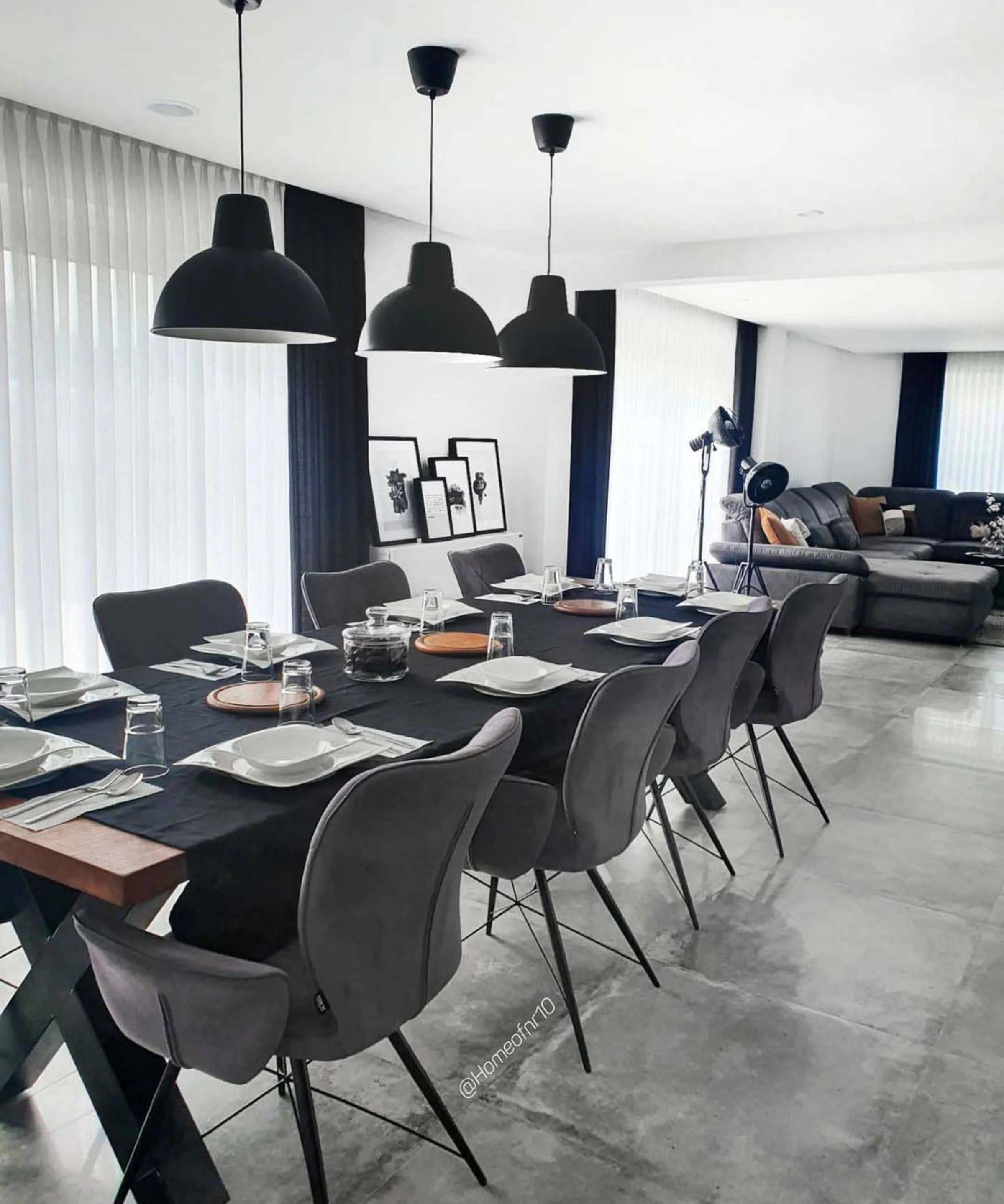 Ein stilvoll eingerichtetes Esszimmer mit langer Tafel und modernen Leuchten von Nolte Living.