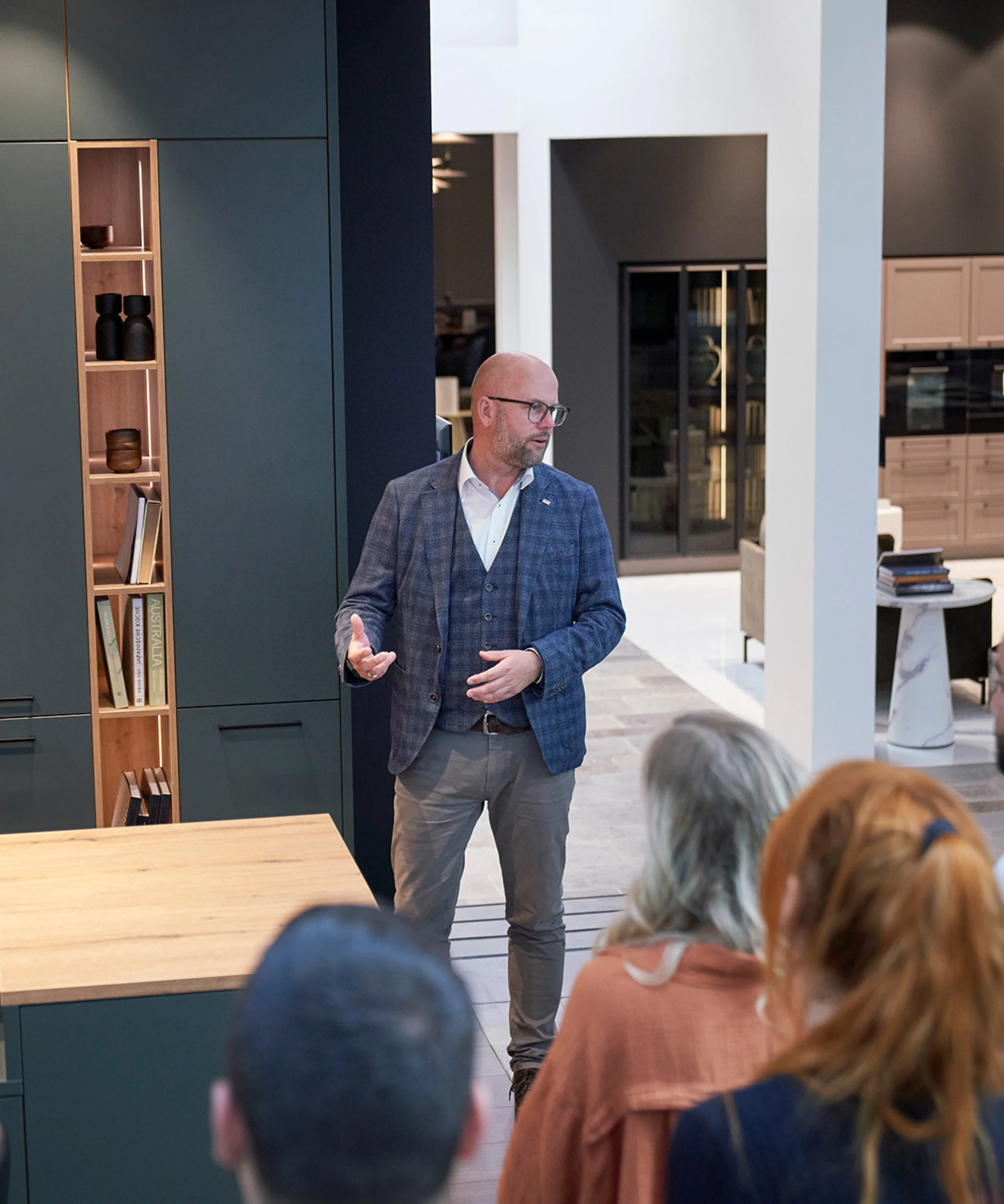 Mężczyzna przemawia przed grupą w nowoczesnej kuchni Nolte Kitchen.