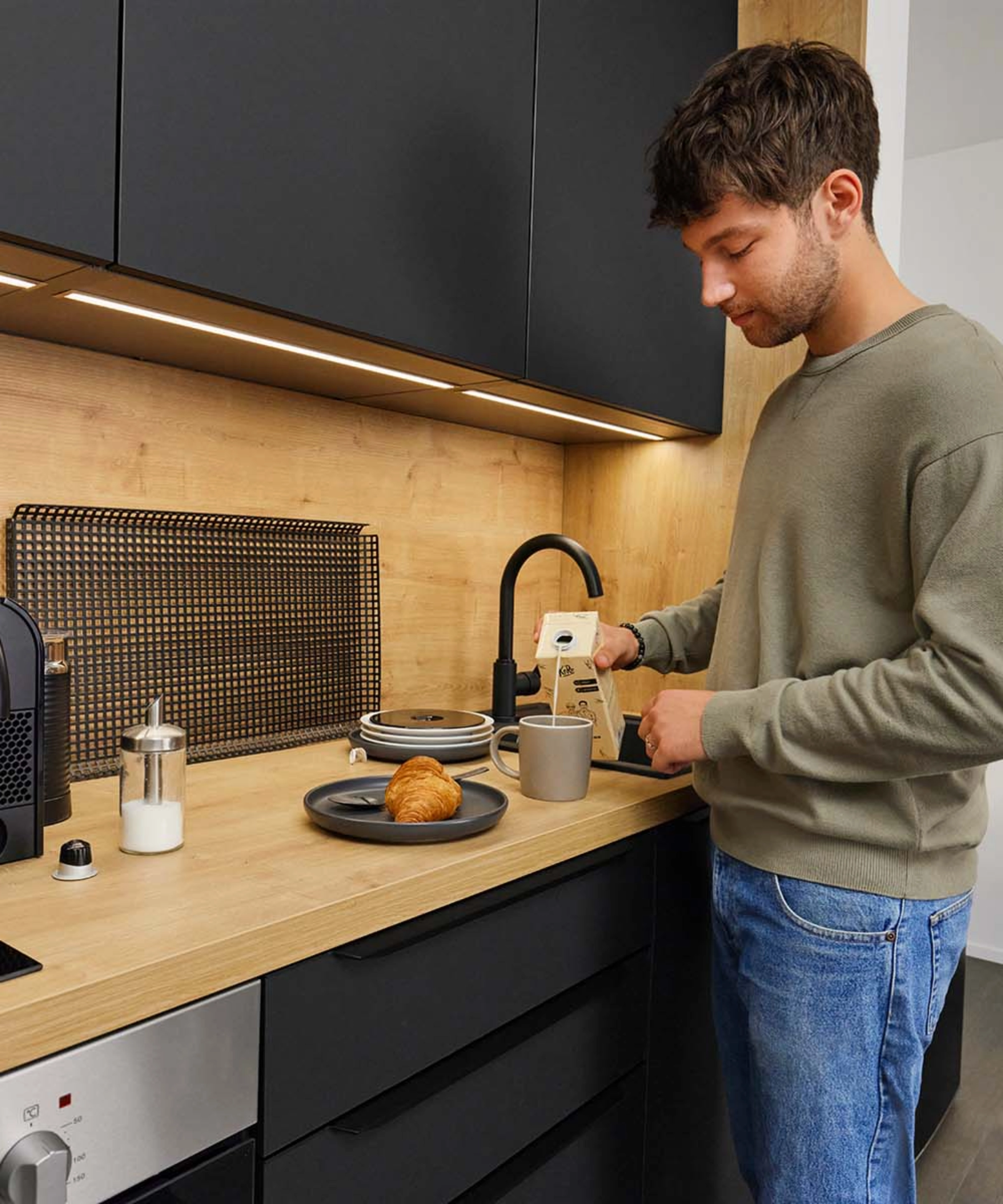 A man making coffee in a modern Nolte Kitchen kitchen.
