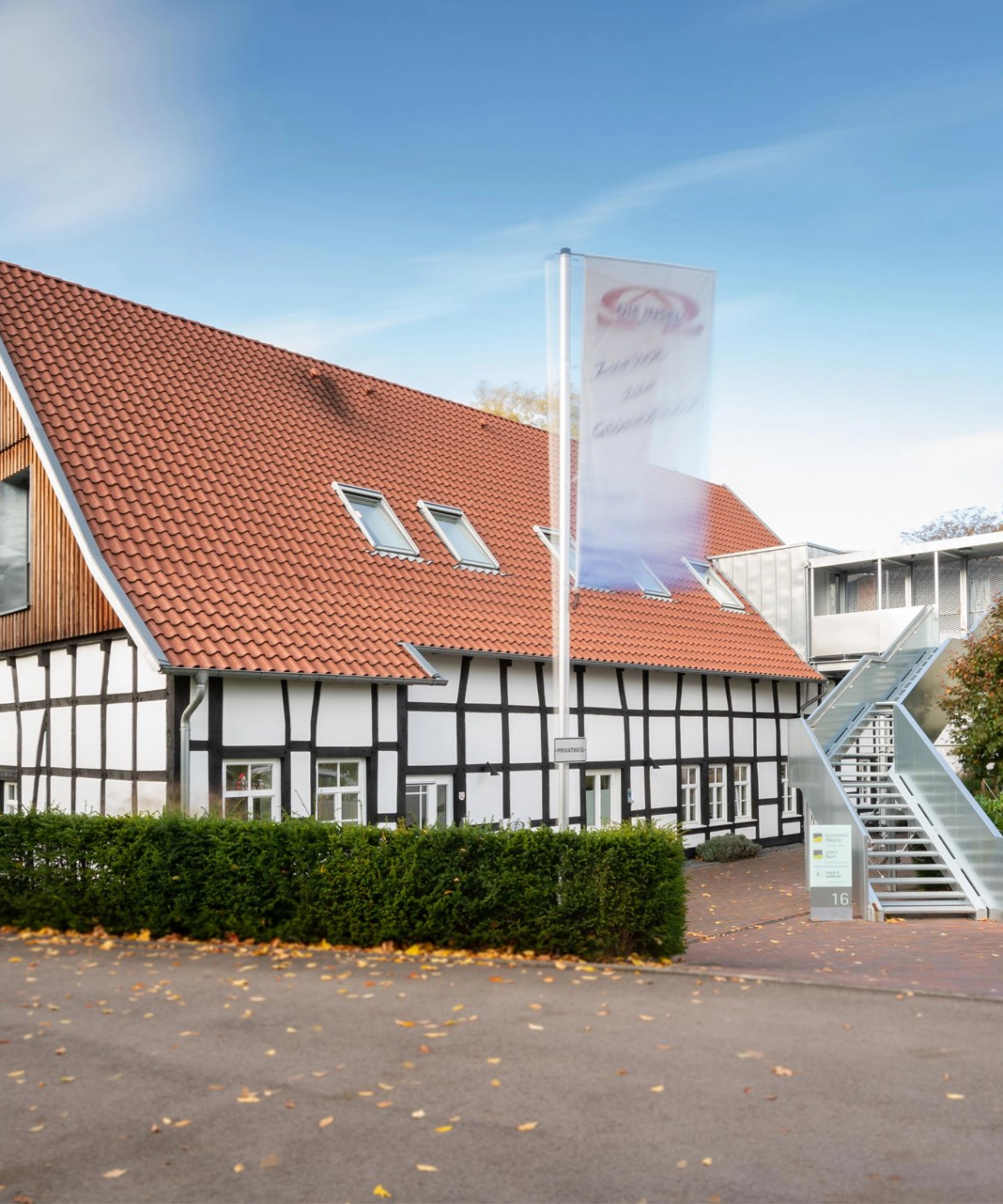 Une maison à colombages au toit rouge se trouve à côté d'un escalier extérieur.