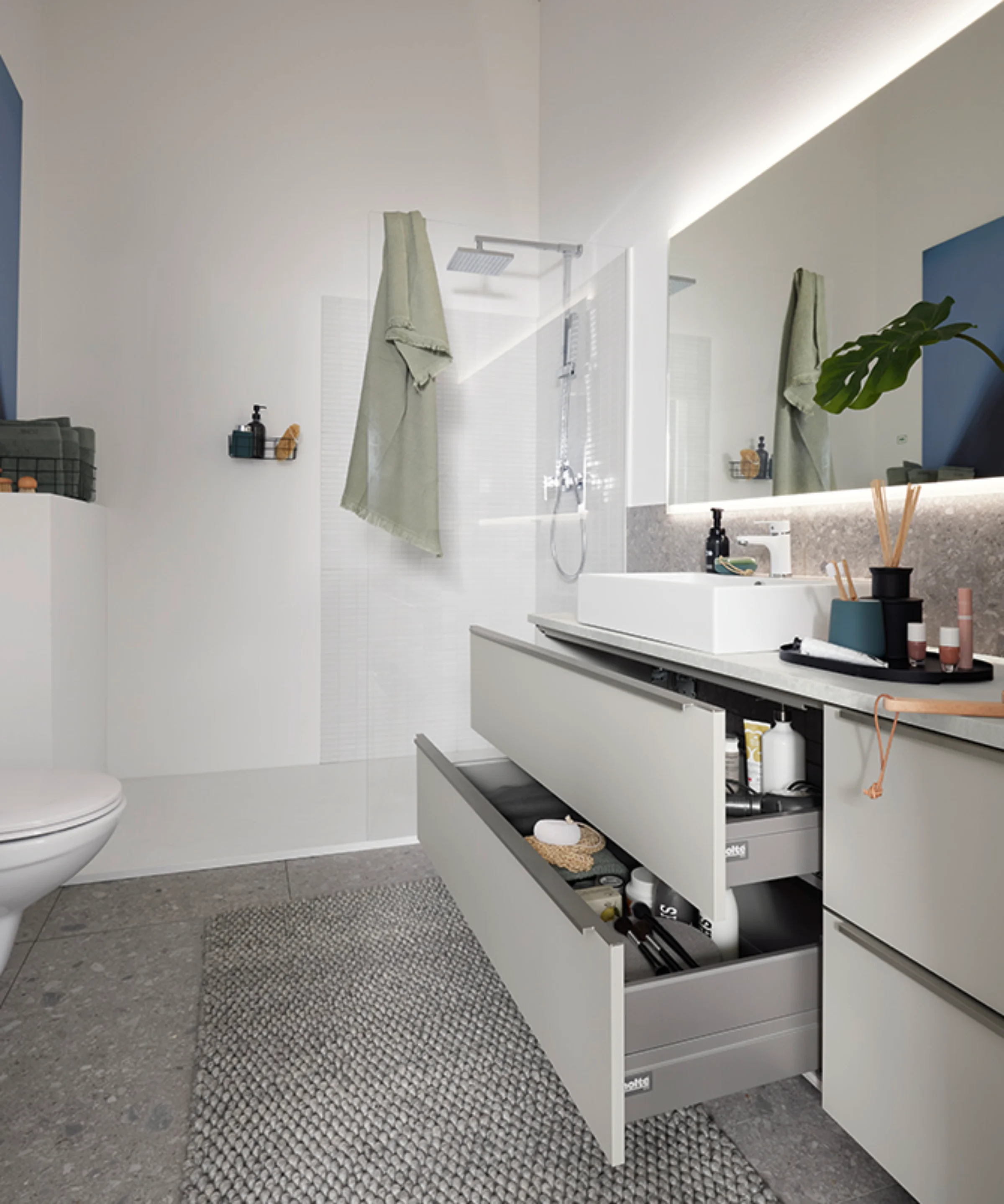 Une salle de bain moderne avec grand miroir et tiroir ouvert de Nolte SPA.