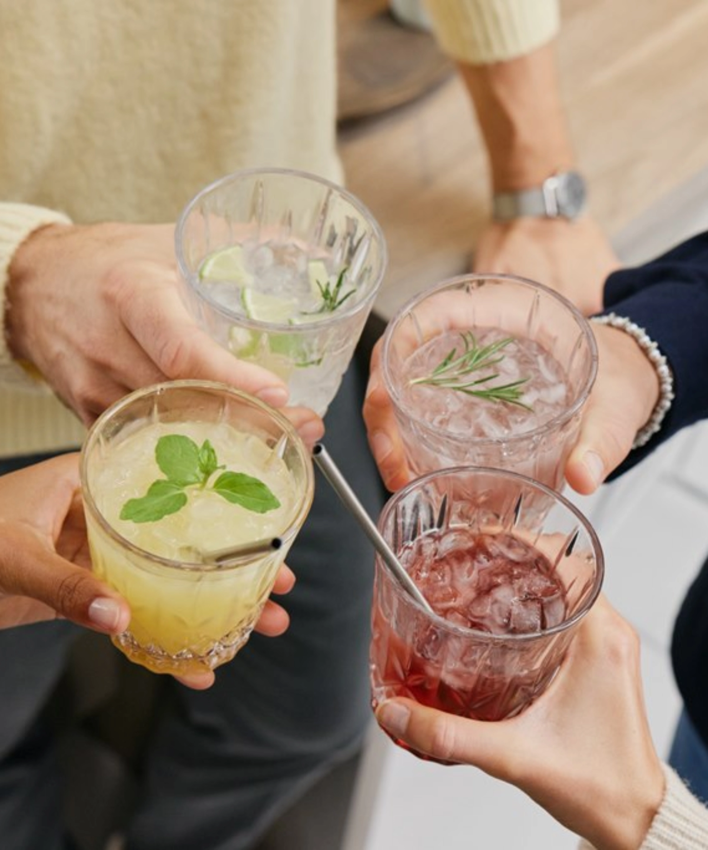 Quatre personnes trinquent avec différents cocktails, Nolte Kitchen.