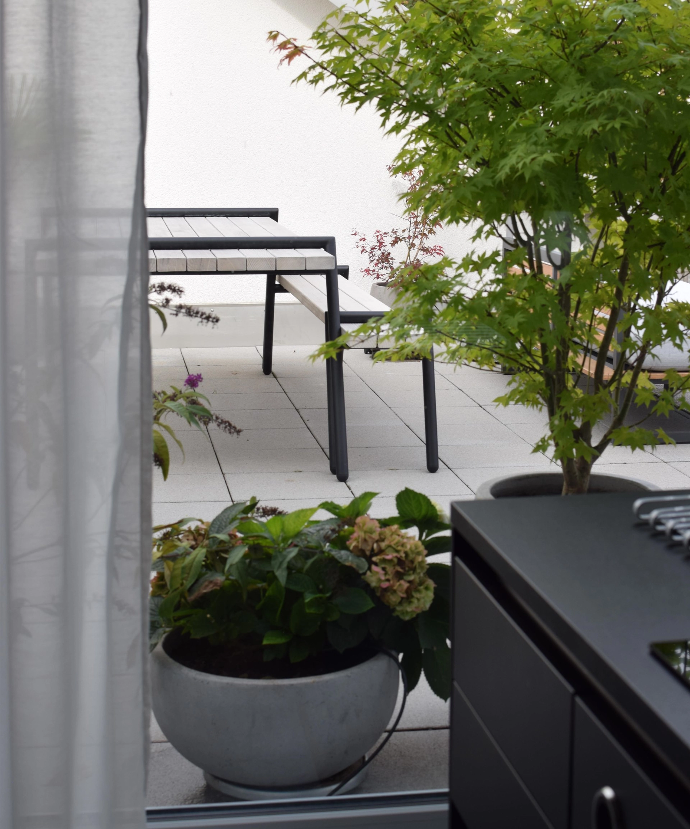 Un espace extérieur moderne avec des plantes et des sièges sur une terrasse.