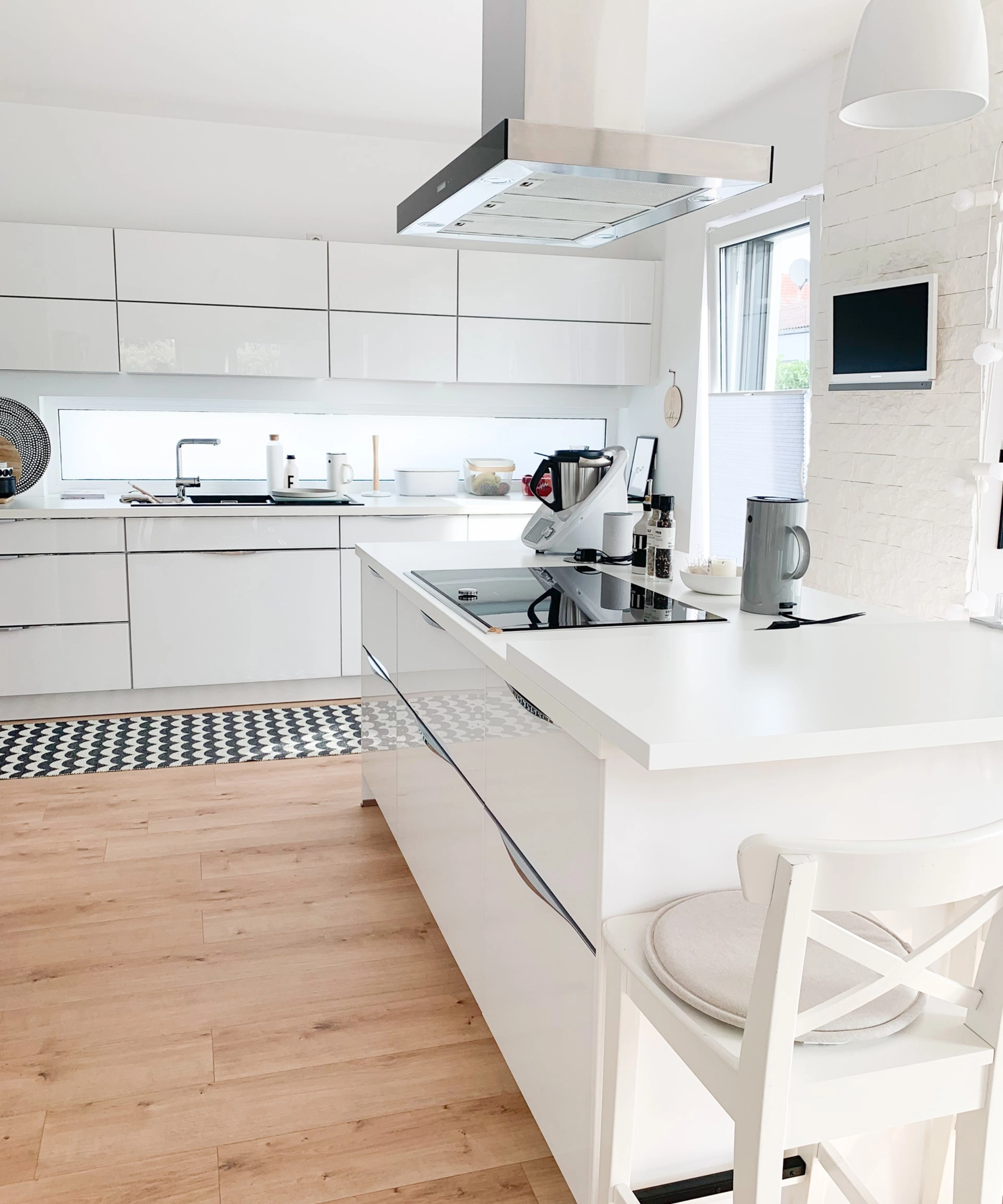 Une cuisine moderne et lumineuse avec des armoires blanches et un îlot; Nolte Kitchen.