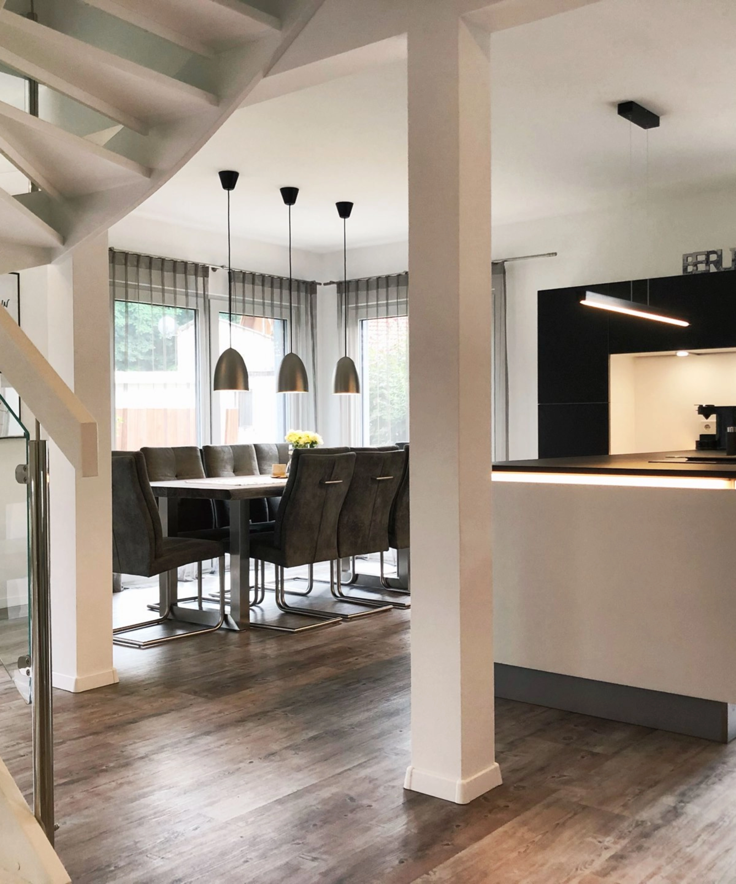 Cucina moderna Nolte con zona pranzo e scala in un open space.