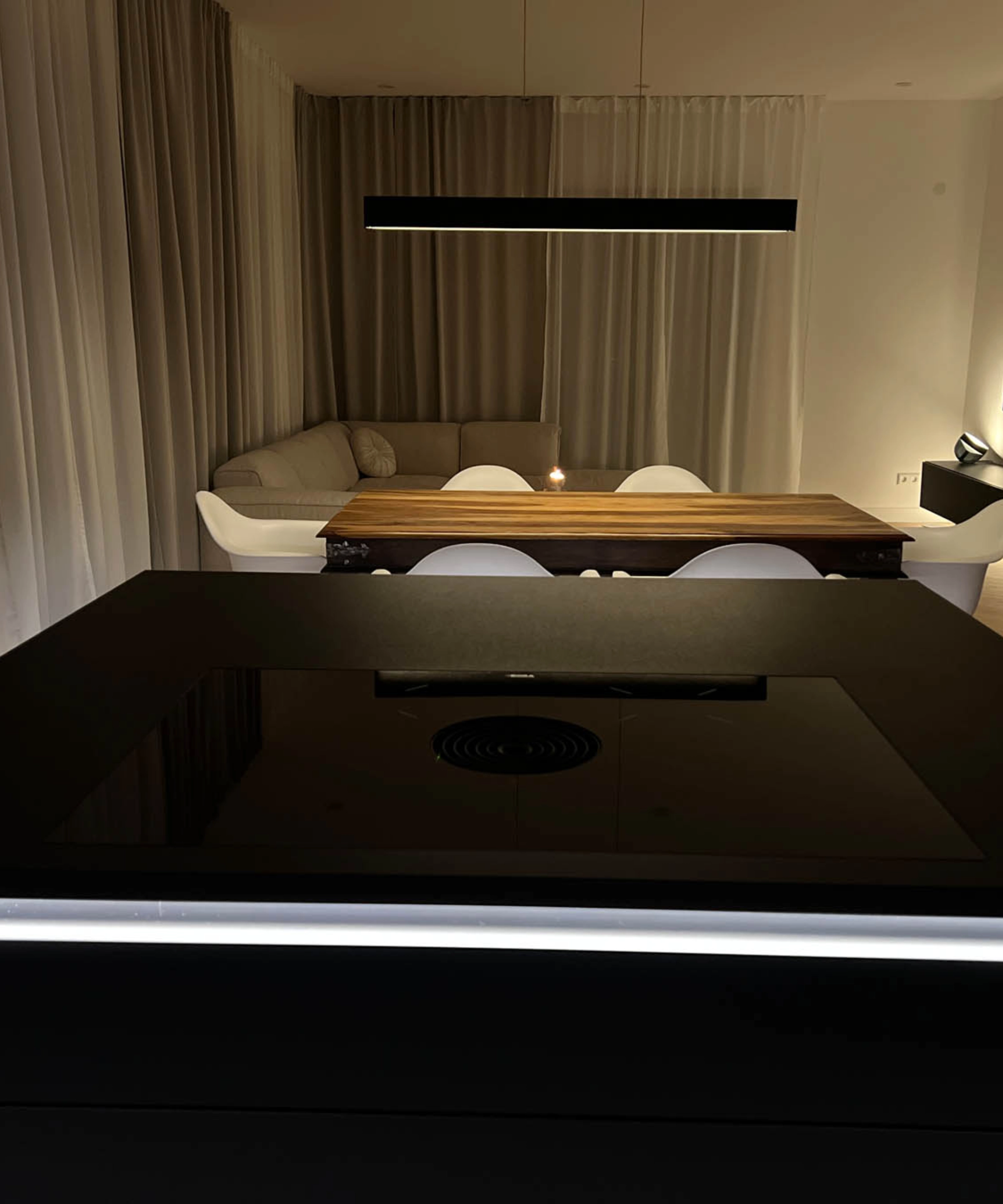 Un salon moderne avec table à manger et canapé au design élégant de Nolte Living.