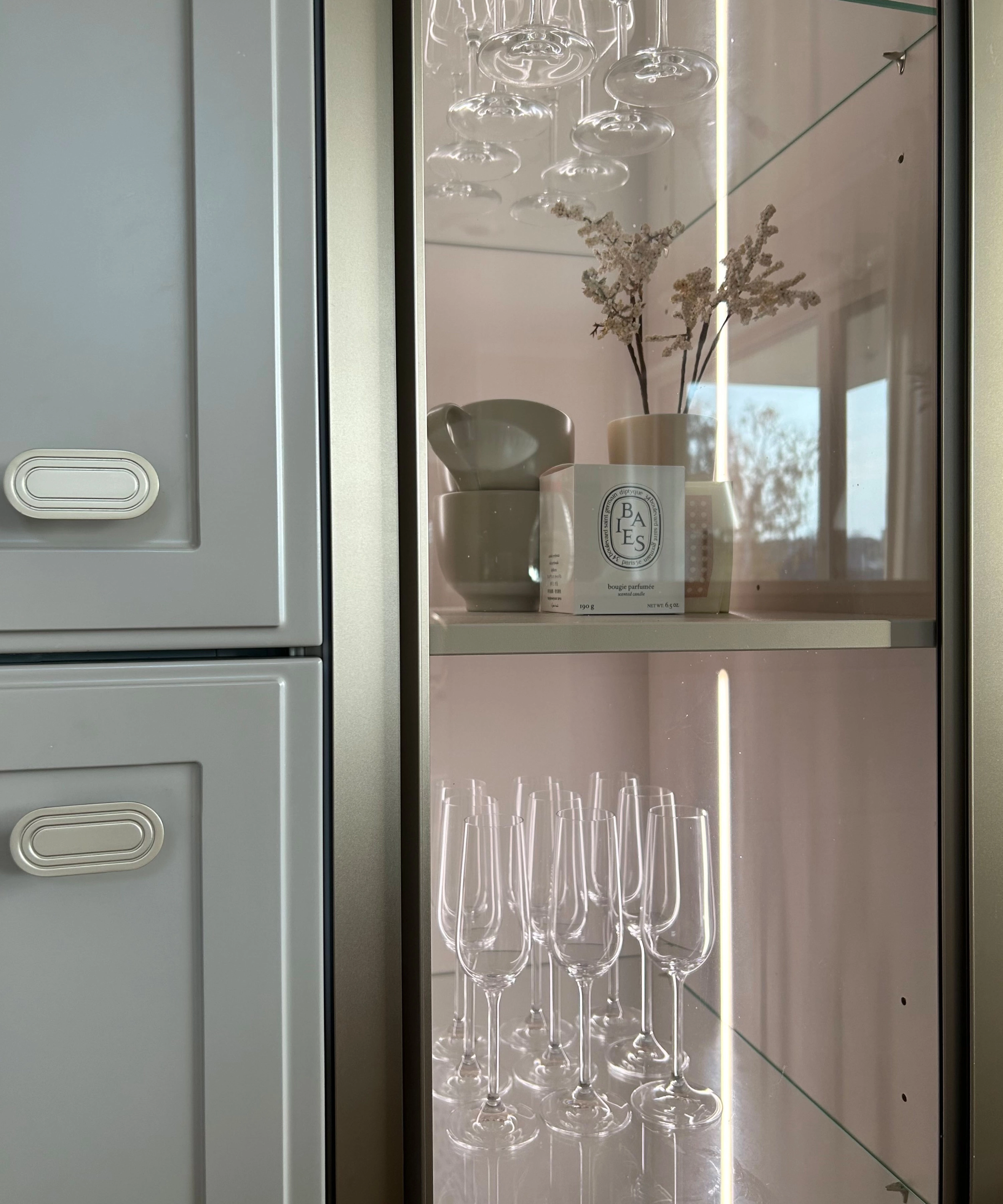 Vetrina in vetro con bicchieri da vino e decorazioni in una cucina, Nolte Kitchen.