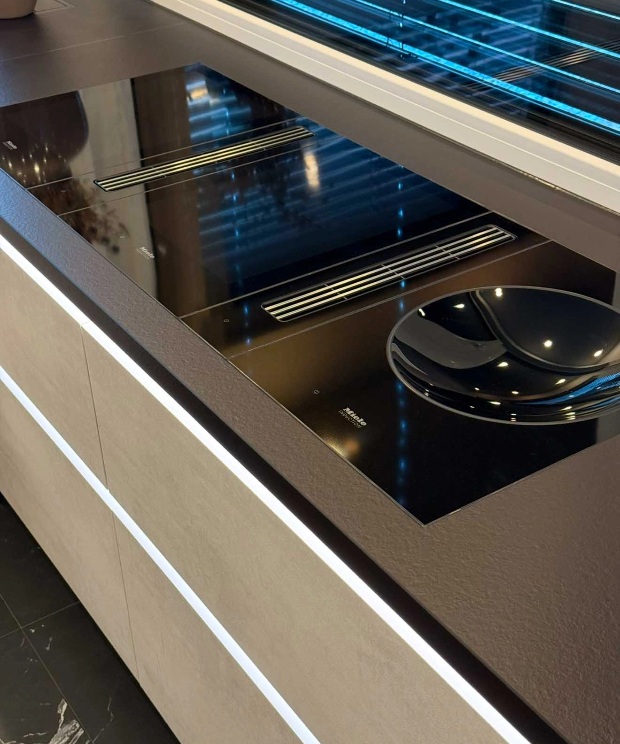 Une cuisine moderne avec une plaque noire et des finitions élégantes de Nolte Kitchen.