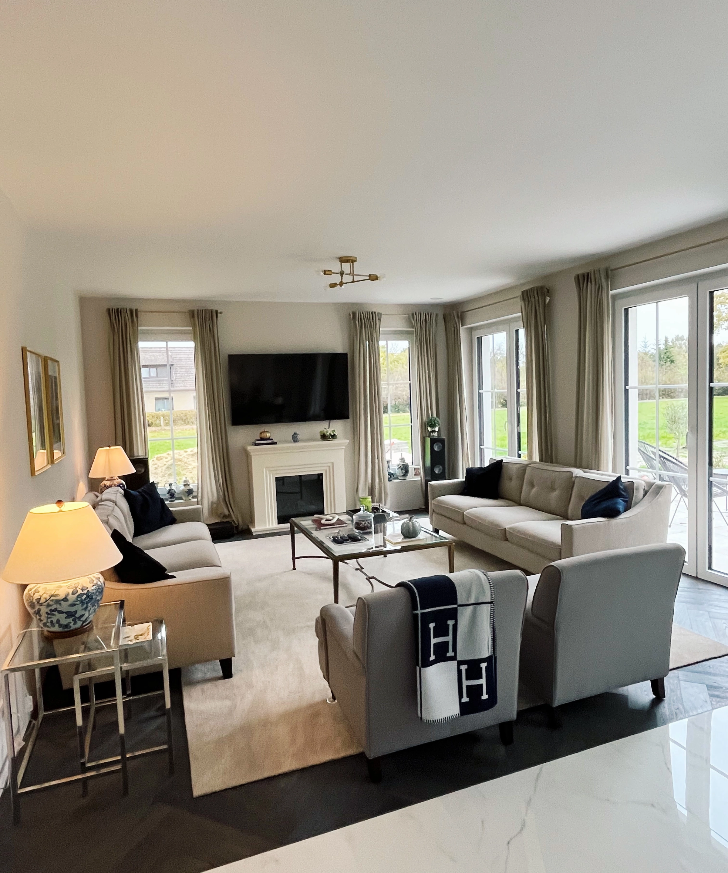Un salon avec canapés et fauteuils, décoré de coussins et couvertures. Nolte Living.