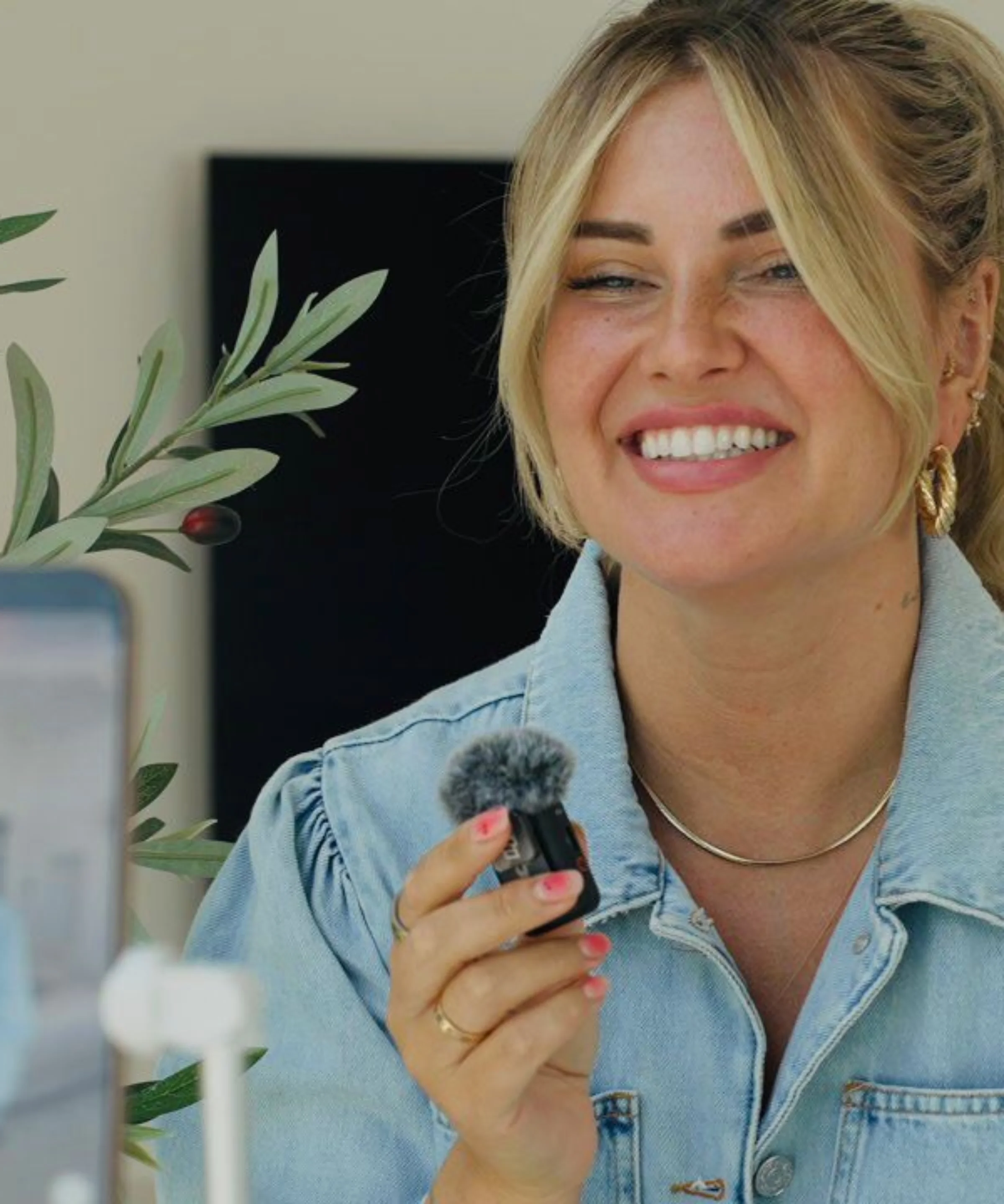 Une femme tient un micro et sourit à la caméra.