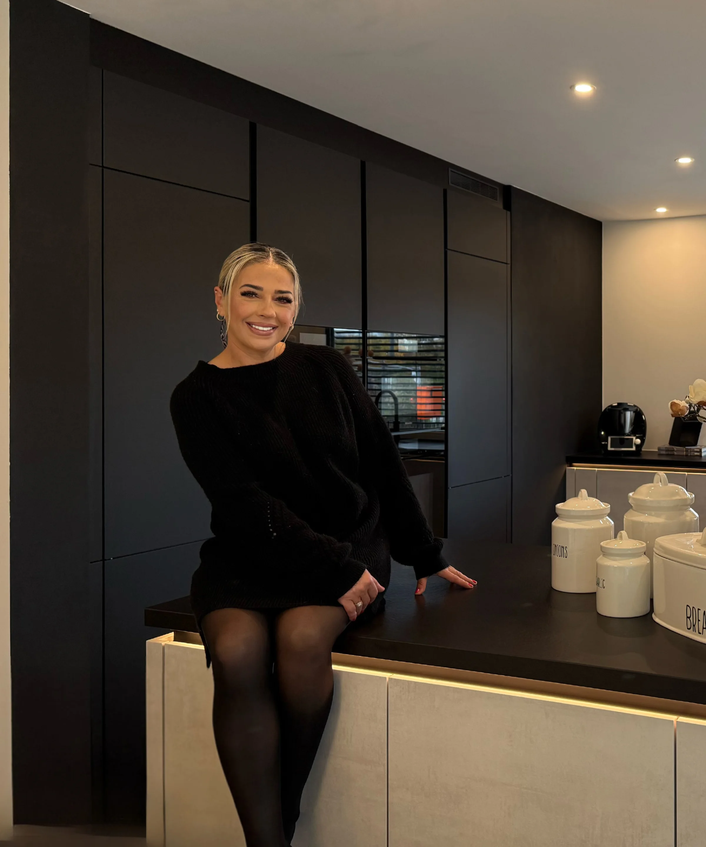 Eine moderne Küche mit dunklen Schränken und stilvollen Dekorationen. Nolte Küchen.