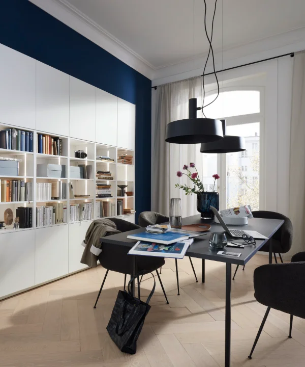 Nowoczesny salon z eleganckim regałem, stołem i krzesłami, pasującymi do Nolte Living.