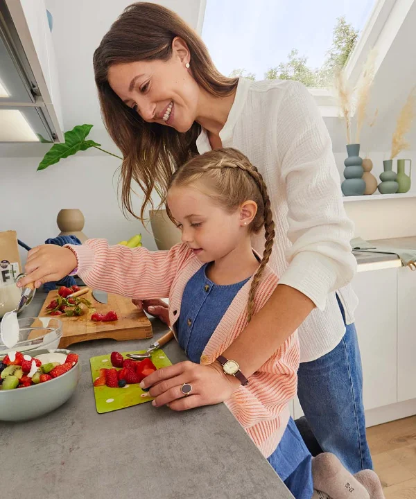 Eine Frau und ein Kind bereiten in einer modernen Küche Speisen zu, Nolte Küchen.