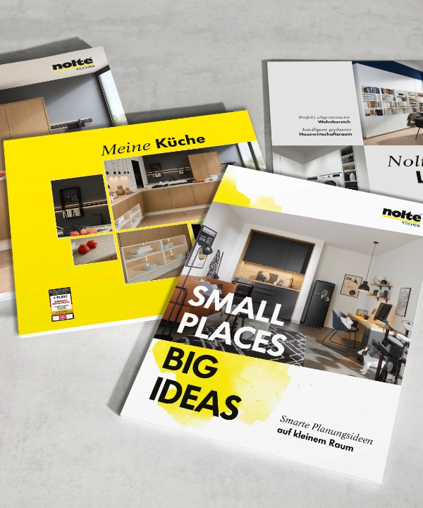 Quatre brochures sur Nolte Kitchen, Nolte Living et NolteNeo Designs sont posées sur une table.
