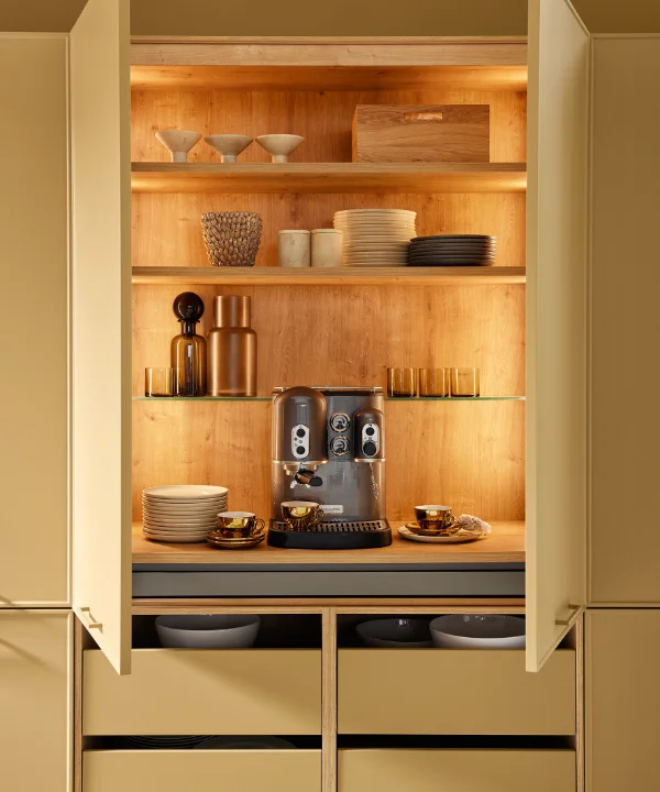 Open kasten in de keuken met servies en een koffiezetapparaat. Nolte Keukens.