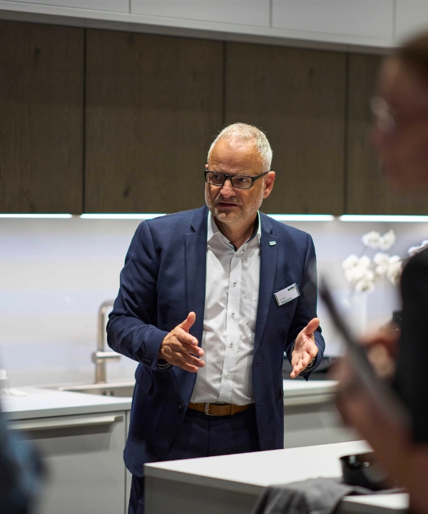 Dans une cuisine moderne, des personnes discutent ; Nolte Kitchen.