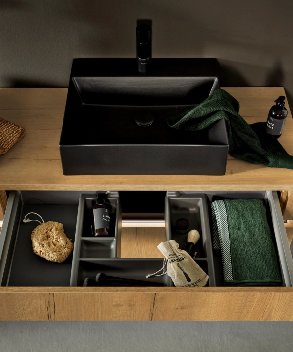 Een moderne badkamer met houten kast en zwarte wastafels, Nolte SPA.