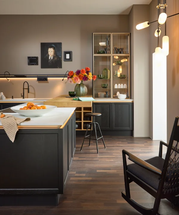 A modern kitchen with dark cabinets and flowers, Nolte Kitchen.