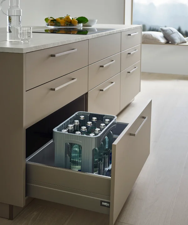 Eine moderne Küche mit offener Schublade, die Flaschen enthält. Nolte Küchen.