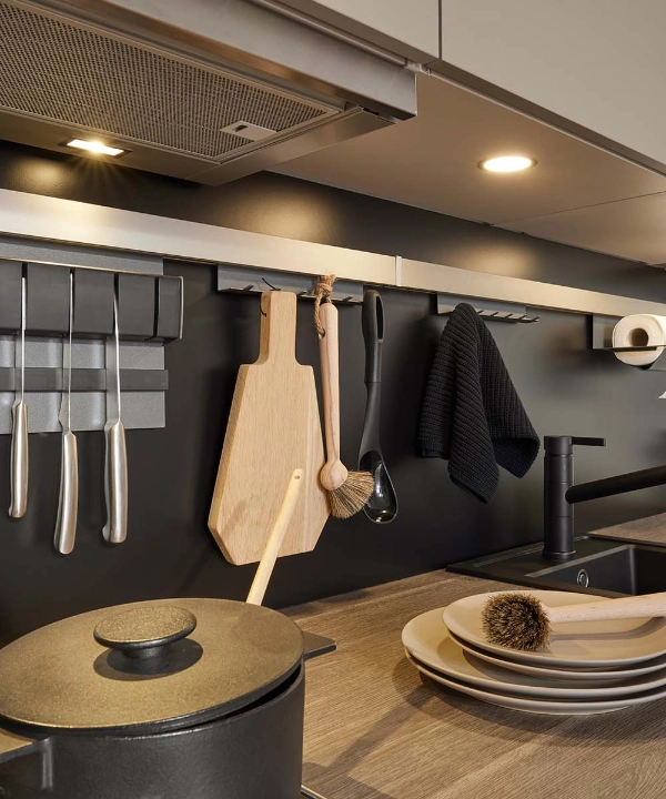 A modern kitchen with wall-mounted utensils and dishes on the countertop by Nolte Kitchen.