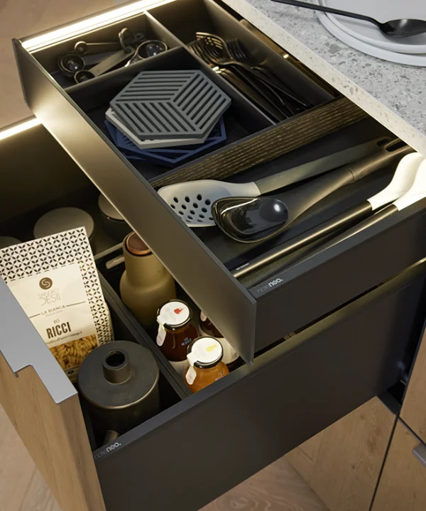 Un tiroir de cuisine ouvert avec couverts et épices dans une cuisine moderne Nolte.