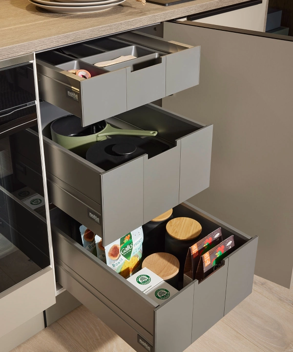 Open kitchen drawers with utensils and spices in a modern Nolte kitchen setting.